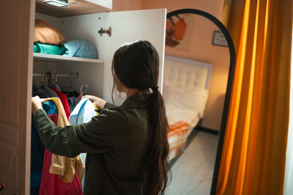 Woman organizing clothes in a beautifully structured wardrobe
